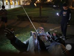 People film the only statue of a Confederate general, Albert Pike, in the nation's capital after it was toppled by protesters and set on fire in Washington early Saturday, June 20, 2020. It comes on Juneteenth, the day marking the end of slavery in the United States, amid continuing anti-racism demonstrations following the death of George Floyd in Minneapolis.(AP Photo/Maya Alleruzzo)