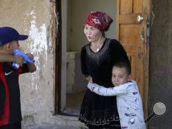 Alif Baqytali hugs his mother, Gulnar Omirzakh, at their new home in Shonzhy, Kazakhstan. Omirzakh, a Chinese-born ethnic Kazakh, says she was forced to get an intrauterine contraceptive device, and that authorities in China threatened to detain her if she didn't pay a large fine for giving birth to Alif, her third child. (AP Photo/Mukhit Toktassyn)