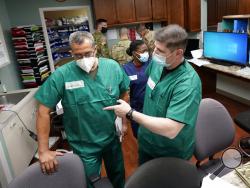FILE - In this July 16, 2020 file photo, Registered nurses Army Lt. Col. Oswaldo Martinez, left, and Maj. Andrew Wieher, right, with the Urban Augmentation Medical Task Force, work to setup a nurses station inside a wing at United Memorial Medical Center, in Houston. Texas reported a new daily record for virus deaths Friday and more than 10,000 confirmed cases for the fourth consecutive day. (AP Photo/David J. Phillip)