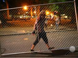 Protesters relocate a fence in front of the Justice Center, Saturday, July 18, 2020, during another night of protests in Portland, Ore. (Mark Graves/The Oregonian via AP)
