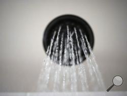 Water flows from a showerhead on Wednesday, Aug. 12, 2020, in Portland, Ore. The Trump Administration wants to change the definition of a showerhead to let more water flow. But consumer and conservation groups said the Department of Energy’s proposed loosening of a 28-year-old energy law is silly, unnecessary and wasteful, especially as the West bakes through a historic two-decade-long megadrought. (AP Photo/Jenny Kane)