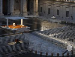 FILE - In this photo taken on March 27, 2020, Pope Francis, white figure standing alone at center, delivers an Urbi et orbi prayer from the empty St. Peter's Square, at the Vatican. If ever there was a defining moment of Pope Francis during the coronavirus pandemic, it came on March 27, the day Italy recorded its single biggest daily jump in fatalities. From the rain-slicked promenade of St. Peter’s Basilica, Francis said the virus had shown that we’re all in this together, that we need each other and need 