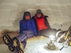 In this handout photo provided by British Antarctic Survey, field guide Sasha Doyle, left, and meteorological observer Jack Farr, right, sit in an igloo in Trident area, Adelaide island, in Antarctica in October 2019. Antarctica remains the only continent without COVID-19 and now in Sept. 2020, as nearly 1,000 scientists and others who wintered over on the ice are seeing the sun for the first time in months, a global effort wants to make sure incoming colleagues don't bring the virus with them. (Robert Tayl