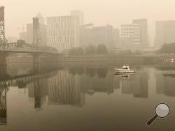 A view of downtown Portland from the East Bank Esplanade is seen on Monday, Sept. 14, 2020. The entire Portland metropolitan region remains under a thick blanket of smog from wildfires that are burning around the state and residents are being advised to remain indoors due to hazardous air quality. (AP Photo/Gillian Flaccus)