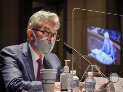 FILE - In this June 30, 2020, file photo Federal Reserve Board Chairman Jerome Powell, reflected in the sneeze guard set up between himself and members of the House Committee on Financial Services, speaks during a hearing on oversight of the Treasury Department and Federal Reserve pandemic response on Capitol Hill in Washington. The Federal Reserve adjusted its inflation target to seek price increases above 2% annually, a move that will likely keep interest rates low for years to come. The Fed on Wednesday,