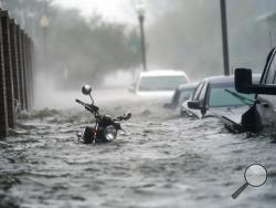 Cars and a motorcycle are underwater as water floods a street, Wednesday, Sept. 16, 2020, in Pensacola, Fla. Hurricane Sally made landfall Wednesday near Gulf Shores, Alabama, as a Category 2 storm, pushing a surge of ocean water onto the coast and dumping torrential rain that forecasters said would cause dangerous flooding from the Florida Panhandle to Mississippi and well inland in the days ahead.(AP Photo/Gerald Herbert)