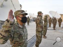 In this photo released by the U.S. Air Force, Airmen deployed to Al-Udeid Air Base, Qatar, raise their right hands during an enlistment ceremony as they transferred into the Space Force at Al-Udeid Air Base, Qatar, Tuesday, Sept. 1, 2020. Space Force now has a squadron of 20 members stationed at the Qatari base in its first foreign deployment. The force represents the sixth branch of the U.S. military and the first new military service since the creation of the Air Force in 1947. (Staff Sgt. Kayla White/U.S