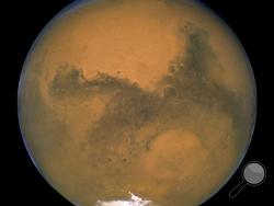 This Aug. 26, 2003 image made available by NASA shows Mars as it lines up with the Sun and the Earth. Photographed by the Hubble Space Telescope, it was about 55.8 million kilometers (34.6 million miles) from Earth. A network of salty ponds may be gurgling beneath Mars’ South Pole alongside a large underground lake, raising the prospect of tiny, swimming Martian life. Italian scientists reported their findings Monday, Sept. 28, 2020 two years after identifying what they believed to be a large subglacial lak