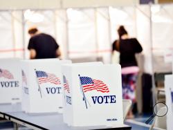 FILE - In this Sept. 8, 2020 photo, voting booths are kept socially distant at the Chesterfield, N.H. polling site. Democrats and Republicans are involved in hundreds of lawsuits across the country relating to the upcoming election. The lawsuits concern the core fundamentals of the American voting process, including how ballots are cast and counted.(Kristopher Radder/The Brattleboro Reformer via AP)