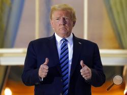 President Donald Trump stands on the balcony outside of the Blue Room as returns to the White House Monday, Oct. 5, 2020, in Washington, after leaving Walter Reed National Military Medical Center, in Bethesda, Md. Trump announced he tested positive for COVID-19 on Oct. 2. (AP Photo/Alex Brandon)