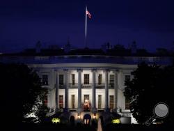 FILE - In this Oct. 5, 2020, file photo an American flag files atop the White House after President Donald Trump arrived from Walter Reed National Military Medical Center via Marine One in Washington. (AP Photo/J. Scott Applewhite, File)