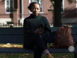 Harvard University graduate student Maya James poses in a park near the university, Wednesday, Oct. 14, 2020, in Cambridge, Mass. Law enforcement and voting advocates are warning that con artists are exploiting the election with scams targeting voters. James received an email from a political action committee that seemed harmless: if you support Joe Biden, it urged, click here to check you're registered to vote. Instead, she Googled the name of the group and it didn’t exist - a clue the email was a phishing