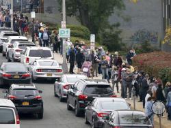 Voters line up in front of the Yonkers Public Library in Yonkers, N.Y., on Saturday, Oct. 24, 2020 as the first day of early voting in the presidential election begins across New York state. (Mark Vergari/The Journal News via AP)