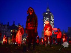 Demonstrators hold a silent vigil in Parliament Square to raise awareness on entertainment and arts world, in London, Saturday, Oct. 31, 2020. Backstage technicians and crews are calling for more fundingfrom the government for the performing arts and hospitality sectors as the coronavirus lockdown is widely anticipated to be extended in England to help control the spread of COVID-19. (AP Photo/Alberto Pezzali)