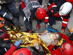 In this photo provided by the government's Search and Rescue agency AFAD, rescue workers, who were trying to reach survivors in the rubble of a collapsed building, surround Ayda Gezgin in the Turkish coastal city of Izmir, Turkey, Tuesday, Nov. 3, 2020, after they have pulled the young girl out alive from the rubble of a collapsed apartment building four days after a strong earthquake hit Turkey and Greece. The girl, Ayda Gezgin, was seen being taken into an ambulance on Tuesday, wrapped in a thermal blanke