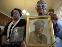 Sisters Barbara Leak-Watkins, right, and Alberta Lynn Fantroy pose with photos of their late father, Alex Leak Jr., at Watkins' home in Greensboro, N.C., on Wednesday, Nov. 4, 2020. The Army veteran died in July after collapsing from dehydration at his assisted-living facility, and the family believes pandemic-related neglect is to blame. As more than 90,000 of America’s long-term care residents have died in a coronavirus pandemic that has pushed staffs to the limit, advocates for the elderly say a tandem w