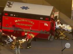 In this image taken from video provided by WISN-TV, emergency crews place two people in waiting ambulances at the Mayfair Mall in Wauwatosa, Wis., on Friday, Nov. 20, 2020. A police dispatcher says officers are responding to "a very active situation" at the suburban Milwaukee mall. The dispatcher said she could not immediately provide further details. Witnesses told WISN-TV that they heard what they believed were eight to 12 shots. (WISN-TV via AP)
