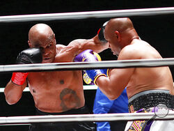 In a photo provided by Triller, Mike Tyson throws a punch during the third round against Roy Jones Jr. in an exhibition boxing bout Saturday, Nov. 28, 2020, in Los Angeles. The bout was unofficially ruled a draw by the WBC judges at ringside. Tyson and Jones fought eight two-minute rounds, and both emerged smiling and apparently healthy from a highly unusual event. (Joe Scarnici/Triller via AP)