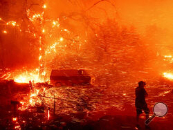 Bruce McDougal prepares to defend his home as the Bond Fire burns though the Silverado community in Orange County, Calif., on Thursday, Dec. 3, 2020. (AP Photo/Noah Berger)