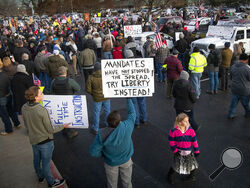 FILE - In this Dec. 8, 2020, file photo, anti-masker demonstrators converge on Central District Health offices in Boise, Idaho, to the protest a meeting deciding on more mandates to combat the spread of COVID-19. Arguments over mask requirements and other restrictions have turned ugly in recent days as the deadly coronavirus surge engulfs small and medium-size cities that once seemed a safe remove from the outbreak. (Darin Oswald/Idaho Statesman via AP, File)