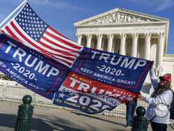 Kathy Kratt of Orlando, Fla., displays her Trump flags as she and other protesters demonstrate their support for President Donald Trump at the Supreme Court in Washington, Friday, Dec. 11, 2020. (AP Photo/J. Scott Applewhite)