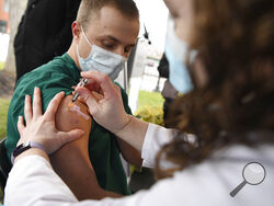 Colleen Teevan, System Pharmacy Clinical Manager at Hartford HealthCare, administers the Pfizer-BioNTech vaccine for COVID-19 to healthcare worker Connor Paleski outside of Hartford Hospital, Monday, Dec. 14, 2020, in Hartford, Conn. (AP Photo/Jessica Hill)