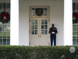 A Marine stands outside the entrance to the West Wing of the White House, signifying the President is in the Oval Office, Monday, Dec. 21, 2020, in Washington. (AP Photo/Evan Vucci)