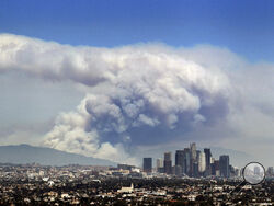 FILE - In this Monday, June 20, 2016 file photo, smoke from wildfires burning in Angeles National Forest fills the sky behind the Los Angeles skyline. The Federal Emergency Management Agency has calculated the risk for every county in America for 18 types of natural disasters, such as earthquakes, hurricanes, tornadoes, floods, volcanos and even tsunamis. And of the more than 3,000 counties, Los Angeles County has the highest ranking in the National Risk Index. (AP Photo/Ringo H.W. Chiu)