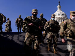 Members of the National Guard walk past the Dome of the Capitol Building on Capitol Hill in Washington, Thursday, Jan. 14, 2021. (AP Photo/Andrew Harnik)