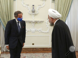 FILE - In this Aug. 26, 2020 file photo, released by the official website of the office of the Iranian Presidency, President Hassan Rouhani, right, welcomes Director General of International Atomic Energy Agency, IAEA, Rafael Mariano Grossi for their meeting in Tehran, Iran. Iran urged the United Nations' nuclear watchdog to avoid publishing “unnecessary” details on Tehran’s nuclear program, state TV reported Sunday, Jan. 17, 2021, a day after Germany, France and Britain said Tehran has “no credible civilia