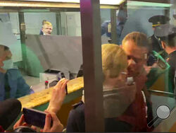 In this photo taken from video, Alexei Navalny kisses his wife Yulia as he is detained by police at the passport control after arriving at Sheremetyevo airport, outside Moscow, Russia, Sunday, Jan. 17, 2021. Russia's prison service says opposition leader Alexei Navalny has been detained at a Moscow airport after returning from Germany. (AP)