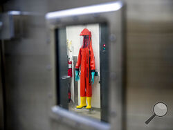 FILE - In this March 19, 2020, file photo, a biosafety protective suit for handling viral diseases are hung up in a biosafety level 4 training facility at U.S. Army Medical Research and Development Command at Fort Detrick in Frederick, Md., where scientists are working to help develop solutions to prevent, detect and treat the coronavirus. China is trying to spread doubt about the effectiveness of Western vaccines and the origin of the coronavirus as a World Health Organization-selected team of scientists a