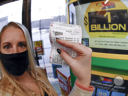 A patron, who did not want to give her name, shows the ticket she had just purchased for the Mega Millions lottery drawing at the lottery ticket vending kiosk in a Smoker Friendly store, Friday, Jan. 22, 2021, in Cranberry Township, Pa. The jackpot for the Mega Millions lottery game has grown to $1 billion ahead of Friday night's drawing after more than four months without a winner. (AP Photo/Keith Srakocic)