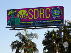 FILE - In this Jan. 13, 2020, file photo, a billboard in San Diego advertises a cannabis dispensary. The state Bureau of Cannabis Control on Thursday said billboard companies must stop selling space for cannabis marketing and take down existing ads on roads that cross state borders. The new regulation covers about three dozen state and interstate routes. (Nelvin C. Cepeda/The San Diego Union-Tribune via AP, File)