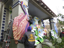 Parade float workers Travis Keene, left, and Joey Mercer position a pelican while fellow crew member Chelsea Kamm, right, looks on while decorating a house in New Orleans on Friday, Jan. 8, 2021. All around the city, thousands of houses are being decorated as floats because the coronavirus pandemic has canceled parades that usually take place on Mardi Gras. (AP Photo/Janet McConnaughey)