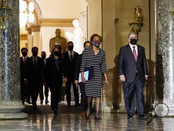 Clerk of the House Cheryl Johnson along with acting House Sergeant-at-Arms Tim Blodgett, lead the Democratic House impeachment managers as they walk through Statuary Hall in the Capitol, to deliver to the Senate the article of impeachment alleging incitement of insurrection against former President Donald Trump, Monday, Jan. 25, 2021 in Washington. (AP Photo/Susan Walsh)
