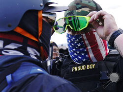 FILE - In this Sept. 26, 2020, file photo, member of the Proud Boys, right, stands in front of a counter protester as members of the Proud Boys and other right-wing demonstrators rally, in Portland. In its annual report set to be released Monday, Feb. 1, 2021, the Southern Poverty Law Center said it identified 838 active hate groups operating across the U.S. in 2020. (AP Photo/John Locher, File)