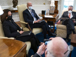 Sen. Patrick Leahy, D-Vt., takes a photo of, from left, Vice President Kamala Harris, President Joe Biden, and Senate Majority Leader Sen. Chuck Schumer of N.Y., during a meeting to discuss a coronavirus relief package, in the Oval Office of the White House, Wednesday, Feb. 3, 2021, in Washington. (AP Photo/Evan Vucci)