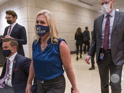 Rep. Marjorie Taylor Greene, R-Ga., walks with fellow House Republicans on Capitol Hill in Washington, Wednesday, Feb. 3, 2021, following a meeting called by House Minority Leader Kevin McCarthy. Democrats are demanding that the GOP leadership remove her from committee assignments because of her history of using social media to endorse outlandish conspiracy theories and violent, racist views. (AP Photo/J. Scott Applewhite)