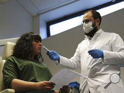 Dr. Clair Vandersteen, right, wafts a tube of odors under the nose of a patient, Gabriella Forgione, during tests in a hospital in Nice, southern France, Monday, Feb. 8, 2021, to help determine why she has been unable to smell or taste since she contracted COVID-19 in November 2020. A year into the coronavirus pandemic, doctors and researchers are still striving to better understand and treat the accompanying epidemic of COVID-19-related anosmia — loss of smell — draining much of the joy of life from an inc