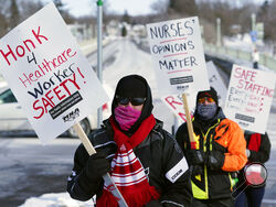 Nurses picket Friday, Feb. 12, 2021 in Faribault, Minn., during a healthcare worker protest of a shortage on protective masks. One year into the COVID-19 pandemic, the U.S. finds itself with many millions of N95 masks pouring out of American factories and heading into storage. Yet there still aren’t nearly enough in ICU rooms and hospitals. (AP Photo/Jim Mone)