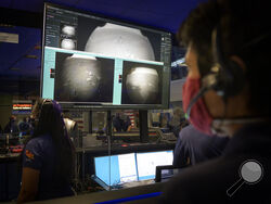 In this photo provided by NASA, members of NASA's Perseverance Mars rover team watch in mission control as the first images arrive moments after the spacecraft successfully touched down on Mars, Thursday, Feb. 18, 2021, at NASA's Jet Propulsion Laboratory in Pasadena, Calif. (Bill Ingalls/NASA via AP)