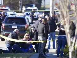 People are comforted by law enforcement as the Jefferson Parish Sheriff's Office deputies investigate a shooting at the Jefferson Gun Outlet in Metairie, La. Saturday, Feb. 20, 2021. A suspect fatally shot two people at a gun store in a suburb of New Orleans on Saturday afternoon, and the shooter also died during gunfire as others engaged the suspect both inside and outside the outlet, authorities said. (Sophia Germer/The Times-Picayune/The New Orleans Advocate via AP)