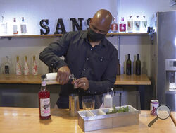 In this March 5, 2021 photo, owner Chris Marshall prepares an alcohol-free cocktail at San Bars in Austin, Texas. According to IWSR Drinks Market Analysis, global consumption of zero-proof beer, wine and spirits is growing two to three times faster than overall alcohol consumption. (AP Photo/John Mone)