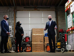 President Joe Biden speaks with owners Kristin Smith and James Smith as he visits Smith Flooring in Chester, Pa., Tuesday, March 16, 2021. (AP Photo/Carolyn Kaster)