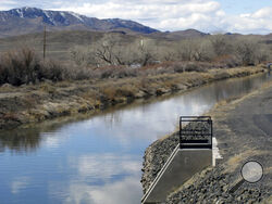 Water flows through an irrigation canal in Fernley, Nev. about 30 miles east of Reno Thursday, March 18, 2021. The town founded a century ago by pioneers lured to the West with the promise of free land and cheap water is suing the U.S. government over plans to renovate the earthen canal that burst and flooded nearly 600 homes in Fernley in 2008. Residents say plans to line parts of it with concrete will eliminate leakage they've counted on for decades to replenish the groundwater aquifer they tap with domes