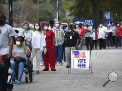 FILE - In this Oct. 12, 2020, file photo, people wait in line for early voting at the Bell Auditorium in Augusta, Ga. The sweeping rewrite of Georgia's election rules that was signed into law by Republican Gov. Brian Kemp Thursday, March 25, 2021, represents the first big set of changes since former President Donald Trump's repeated, baseless claims of fraud following his presidential loss to Joe Biden. Georgia’s new, 98-page law makes numerous changes to how elections will be administered, including a new 