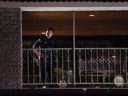 A police officer surveys the scene after a shooting at an office building in Orange, Calif., Wednesday, March 31, 2021. The shooting killed several people, including a child, and injured another person before police shot and wounded the suspect, police said. (AP Photo/Jae C. Hong)