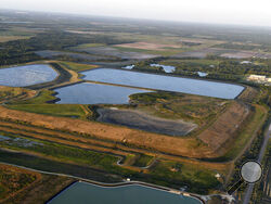 This aerial photo taken from an airplane shows a reservoir near the old Piney Point phosphate mine, Saturday, April 3, 2021 in Bradenton, Fla. Florida Gov. Ron DeSantis declared a state of emergency Saturday after a significant leak at a large pond of wastewater threatened to flood roads and burst a system that stores polluted waters. The pond where the leak was discovered is at the old Piney Point phosphate mine, sitting in a stack of phosphogypsum, a waste product from manufacturing fertilizer that is rad