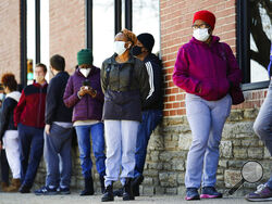 FILE - In this March 29, 2021, file photo, people wearing face masks as a precaution against the coronavirus wait in line to receive COVID-19 vaccines at a site in Philadelphia. Nearly half of new coronavirus infections nationwide are in just five states, including Pennsylvania — a situation that puts pressure on the federal government to consider changing how it distributes vaccines by sending more doses to hot spots. (AP Photo/Matt Rourke, File)